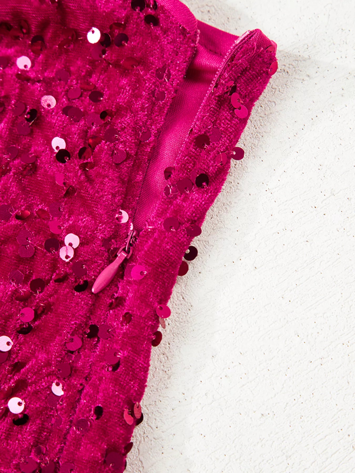 Sequin One-Shoulder Dress zipper detail showcasing vibrant sequins on a pink fabric backdrop.