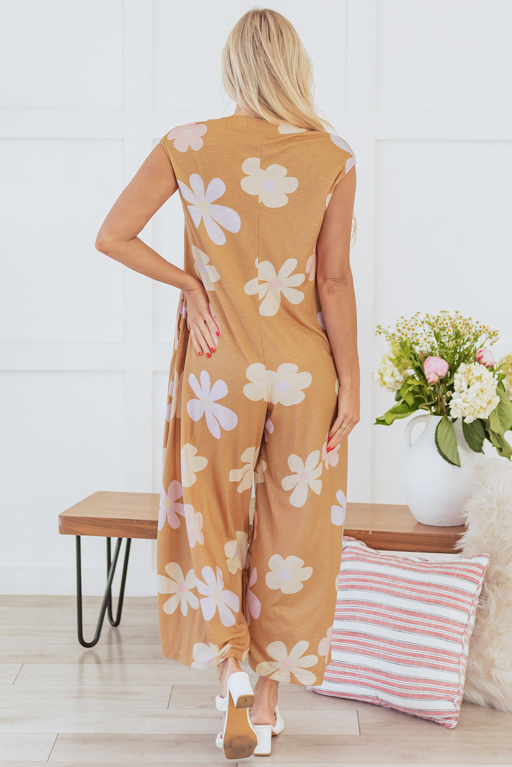 Back view of a Floral Sleeveless Button Up Jumpsuit featuring a vibrant floral print in earthy tones.