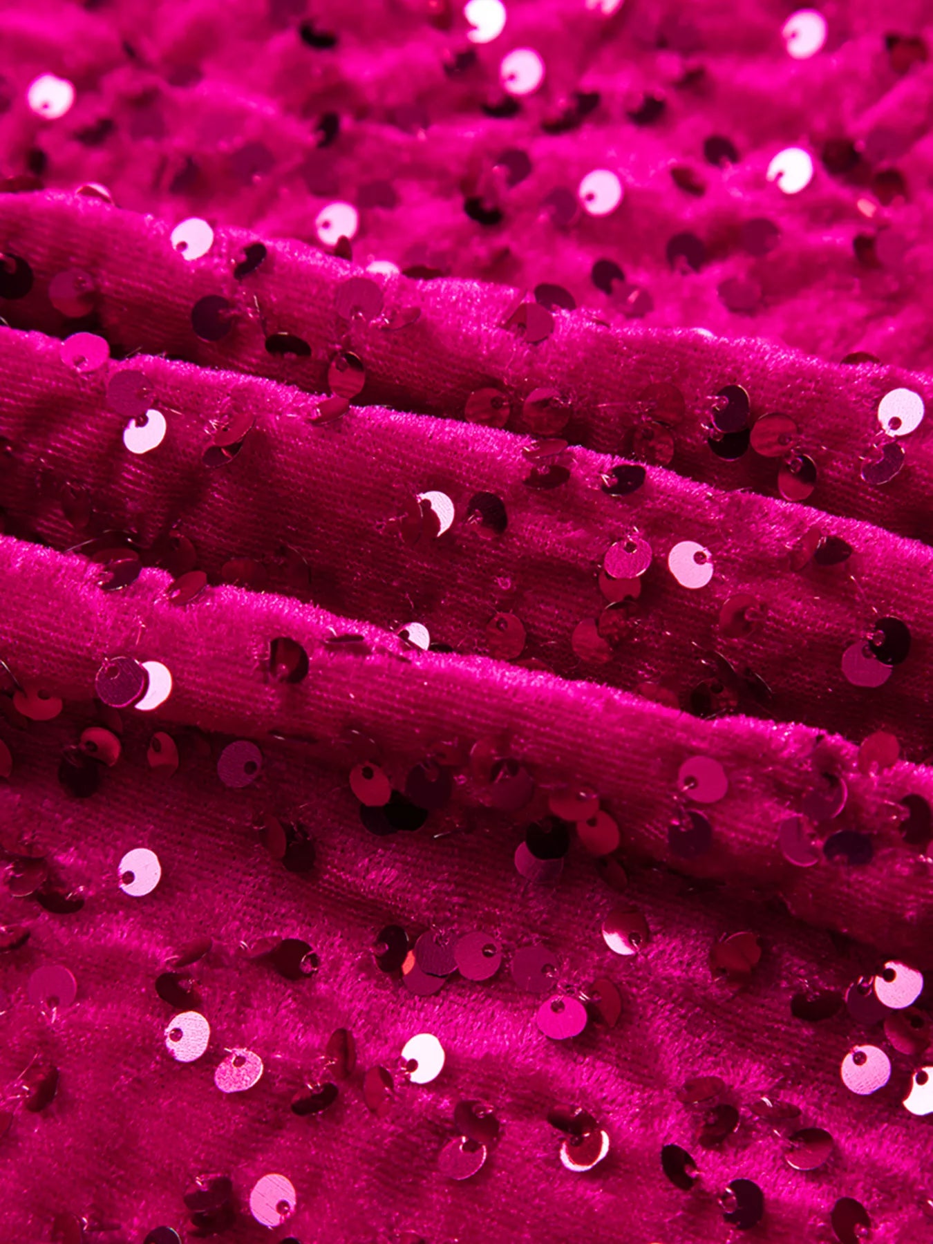 Close-up of vibrant pink fabric with sequins, showcasing the texture of the sequin one-shoulder dress.